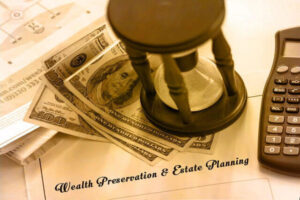 Money pinned by an hourglass on top of wealth preservation and estate planning.
