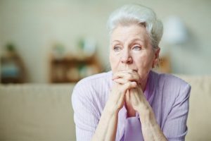 An elderly woman thinking about estate litigation in Long Island.